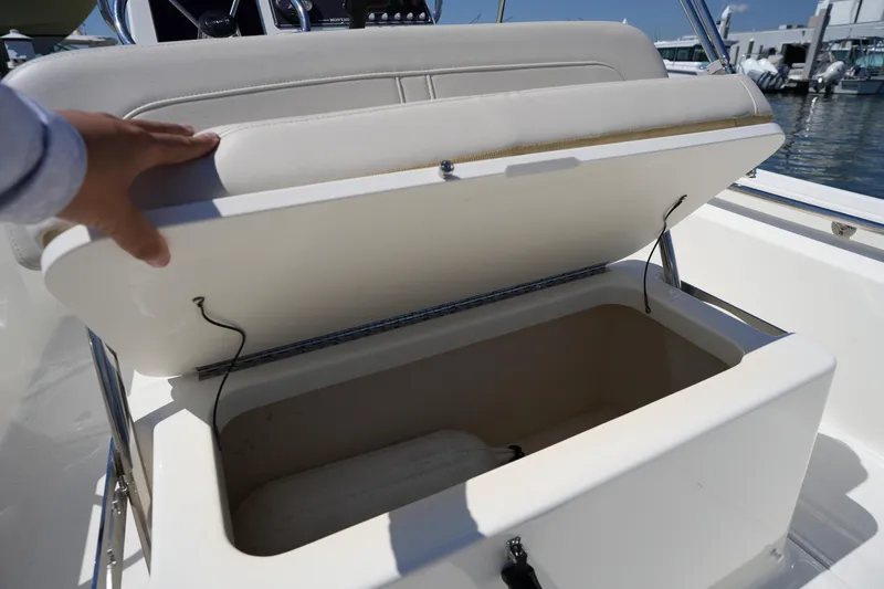 Slide: The Image of 2025 Boston Whaler 170 Montauk boat seat storage compartment open at marina. - 13