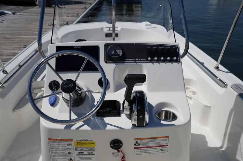 Slide: The Image of 2025 Boston Whaler 170 Montauk boat console with steering wheel and controls. - 15