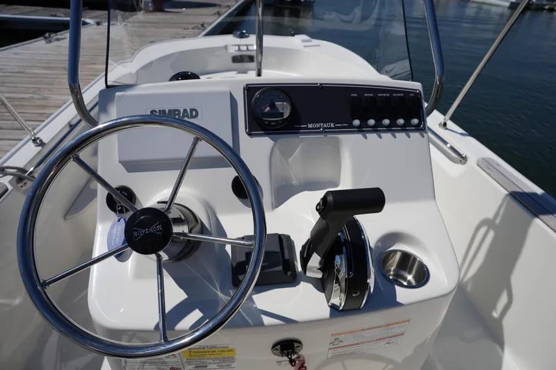 Slide: The Image of 2025 Boston Whaler 170 Montauk boat console with steering wheel and controls. - 20