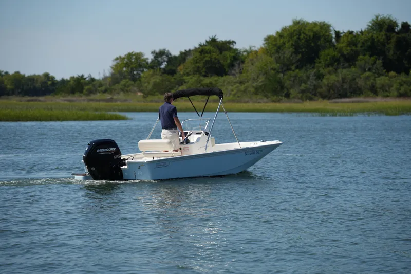 Slide: The Image of 2025 Boston Whaler 170 Montauk boat cruising on a serene lake. - 7