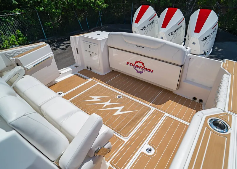 Slide: The Image of 2024 Fountain 32 NX boat interior with white seating and triple outboard engines. - 11