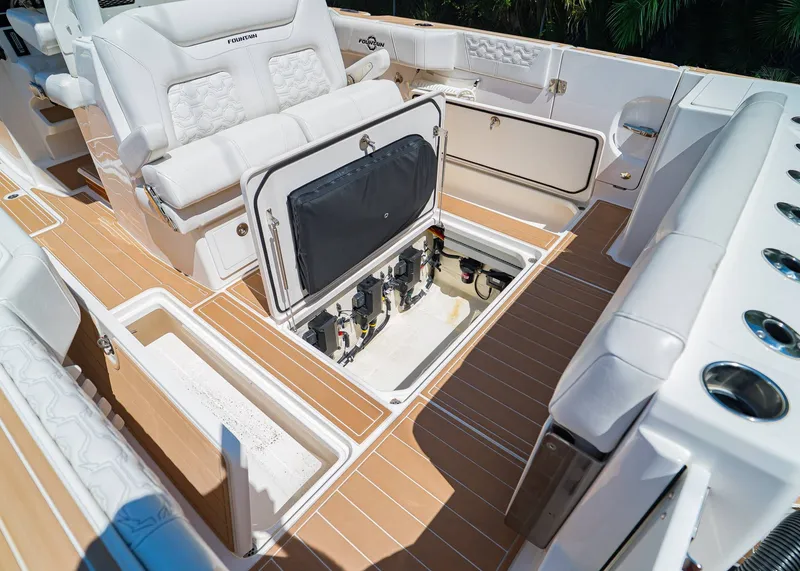 Slide: The Image of 2024 Fountain 32 NX boat interior with open storage compartment and luxurious seating. - 13