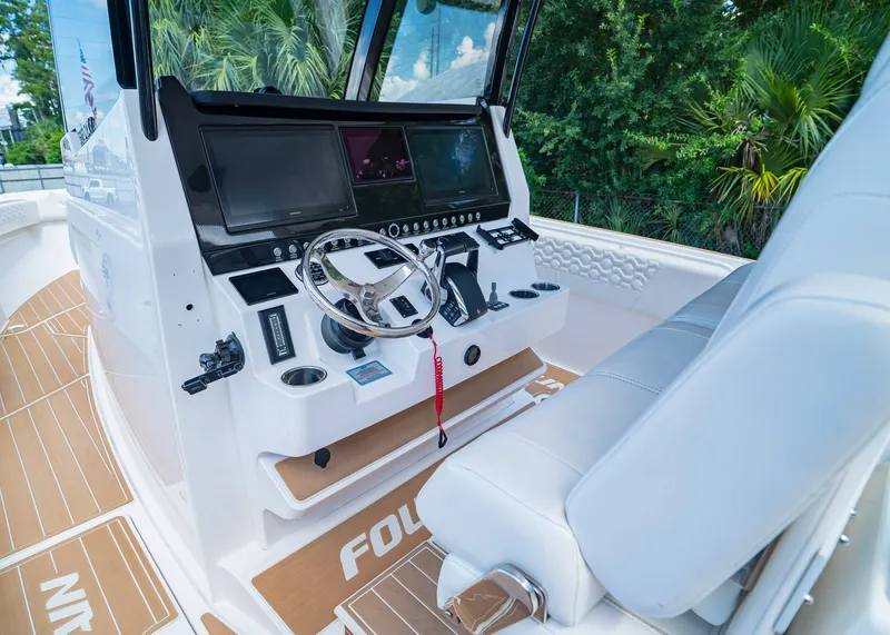 Slide: The Image of 2024 Fountain 32 NX boat cockpit with modern controls and dual screens. - 21