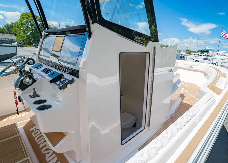Slide: The Image of 2024 Fountain 32 NX boat interior with helm, controls, and cabin door open. - 27