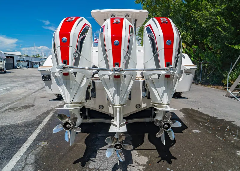 Slide: The Image of 2024 Fountain 32 NX boat with triple outboard engines, parked outdoors. - 3