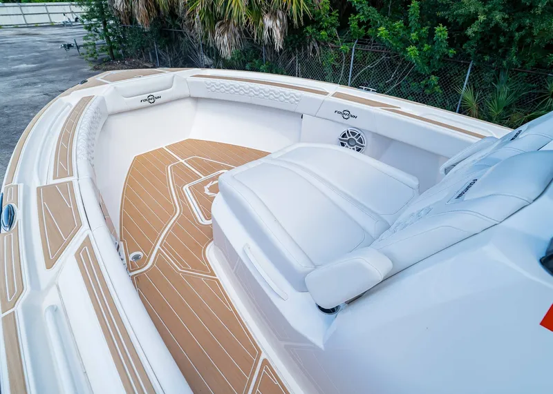 Slide: The Image of 2024 Fountain 32 NX boat interior with white seating and teak flooring. - 36