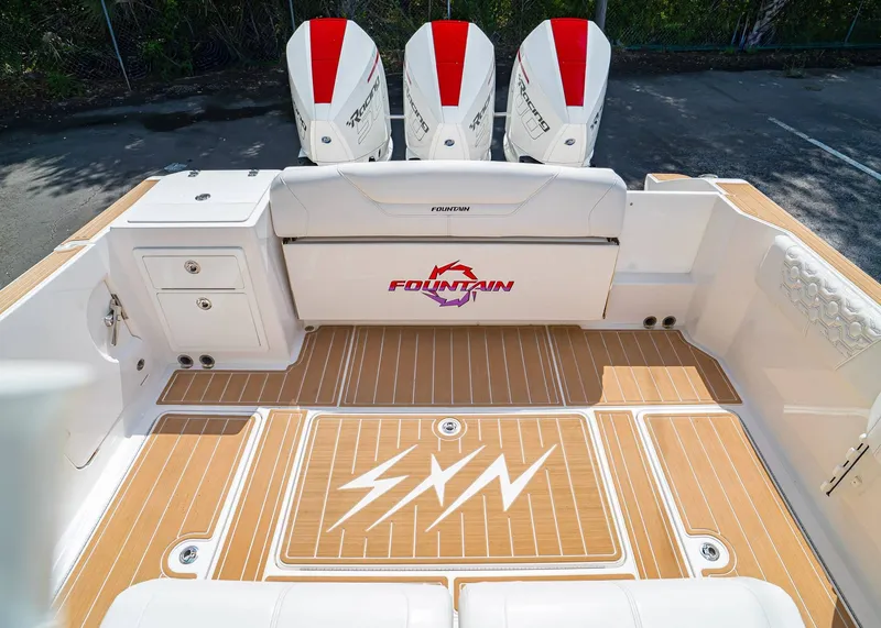 Slide: The Image of 2024 Fountain 32 NX boat deck with triple outboard engines and stylish flooring. - 4