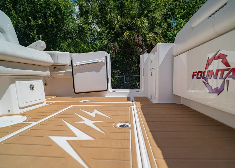 Slide: The Image of 2024 Fountain 32 NX boat deck with logo, featuring sleek seating and wood-patterned flooring. - 8