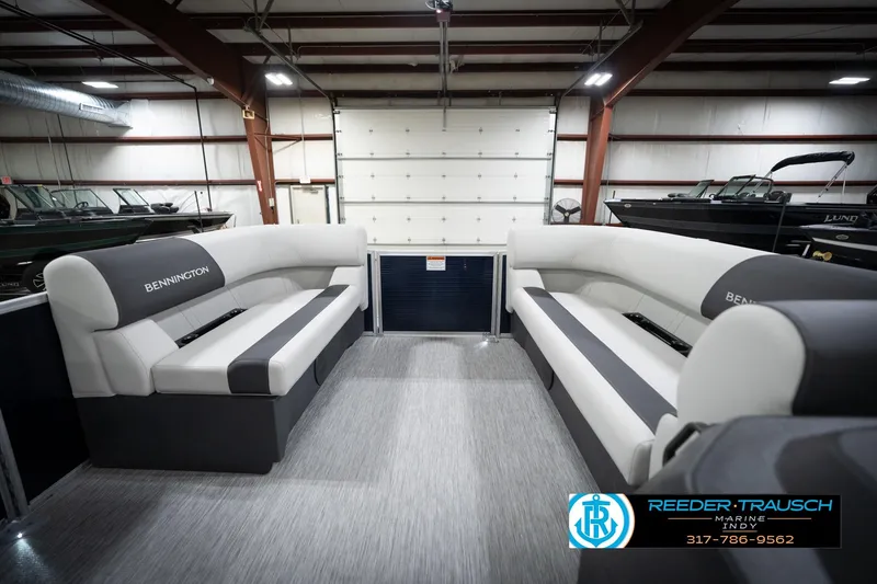 Slide: The Image of 2026 Bennington 20 SL pontoon boat interior with gray seating in a showroom. - 21