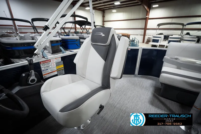 Slide: The Image of 2026 Bennington 20 SL boat interior with modern seating in a showroom. - 23