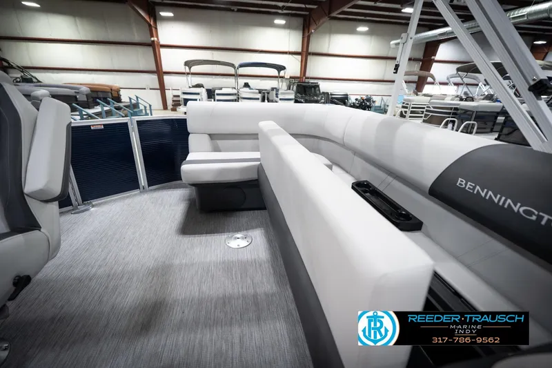 Slide: The Image of 2026 Bennington 20 SL pontoon boat interior with plush seating in a showroom. - 27