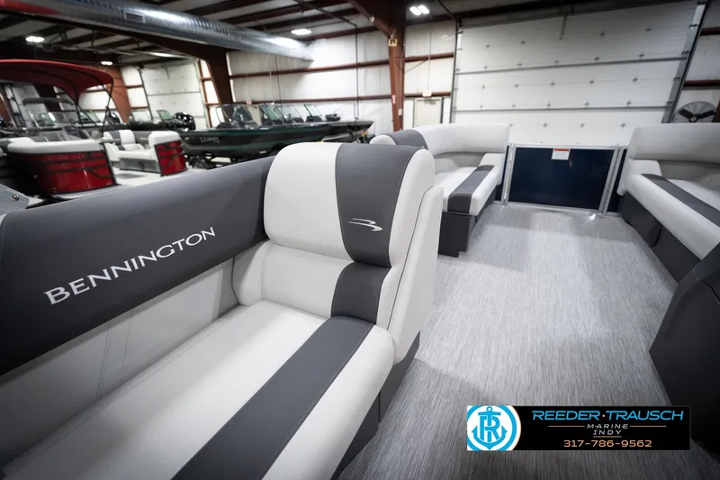 Slide: The Image of 2026 Bennington 20 SL pontoon boat interior with gray and white seating in a showroom. - 29