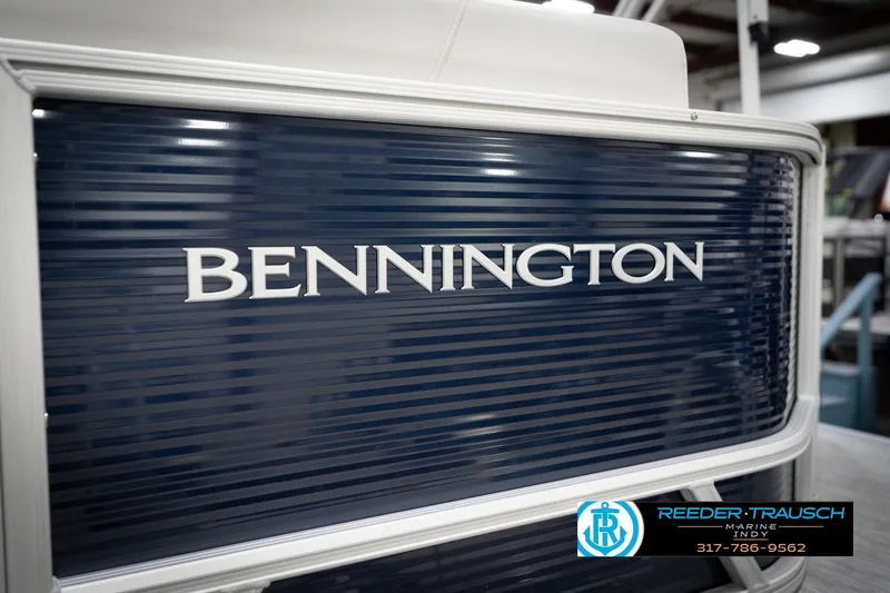 Slide: The Image of 2026 Bennington 20 SL pontoon boat with blue paneling and logo. - 57