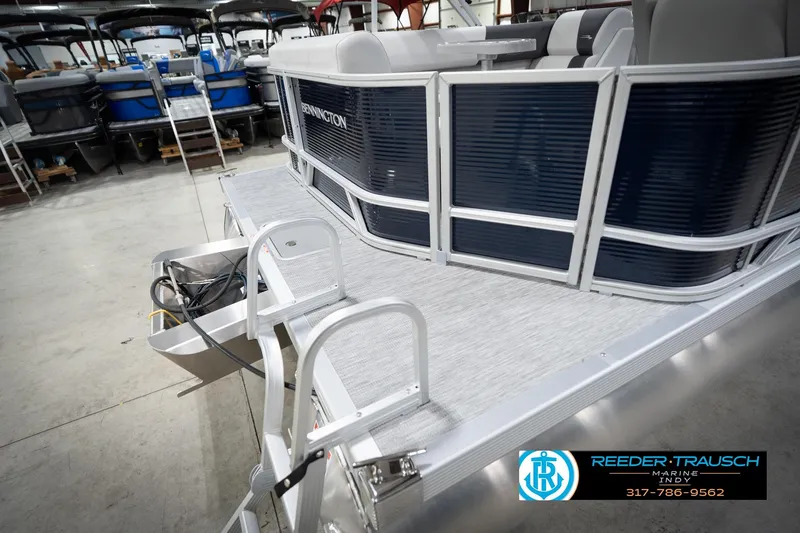 Slide: The Image of 2026 Bennington 20 SL pontoon boat in showroom, featuring sleek design and modern seating. - 58