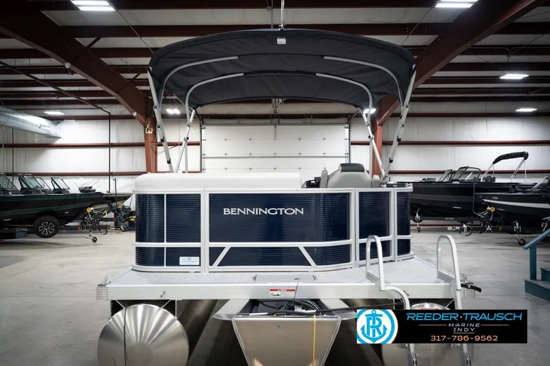 Slide: The Image of 2026 Bennington 20 SL pontoon boat in showroom, featuring sleek design and canopy. - 9