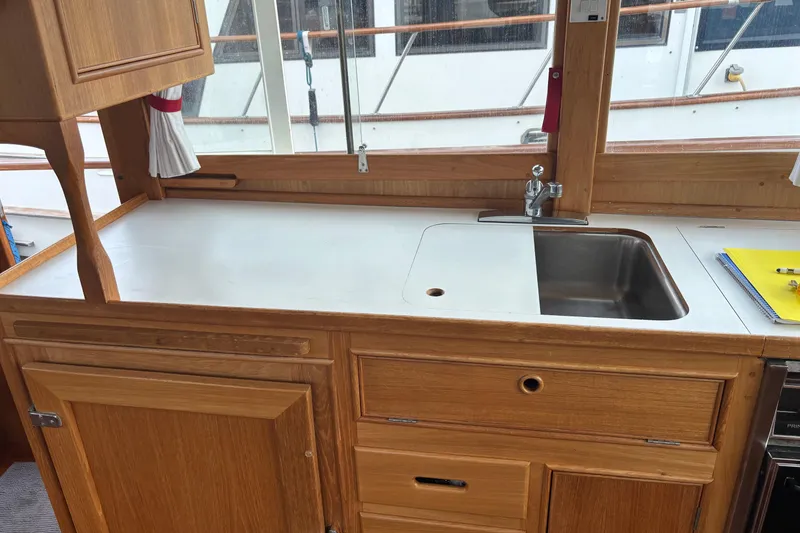 Slide: The Image of 1991 Grand Banks 36 Classic yacht kitchen with wooden cabinetry and stainless steel sink. - 13
