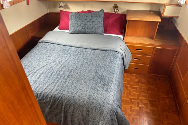 Slide: The Image of Cozy bedroom in 1991 Grand Banks 36 Classic yacht with wood paneling and blue bedding. - 19