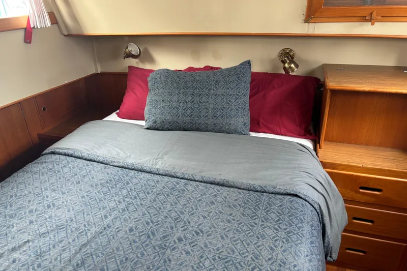 Slide: The Image of Cozy bedroom in 1991 Grand Banks 36 Classic yacht with blue bedding and wooden cabinetry. - 20