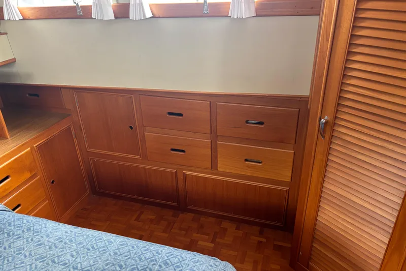 Slide: The Image of Wooden interior cabinetry of a 1991 Grand Banks 36 Classic boat, featuring drawers and louvered doors. - 22
