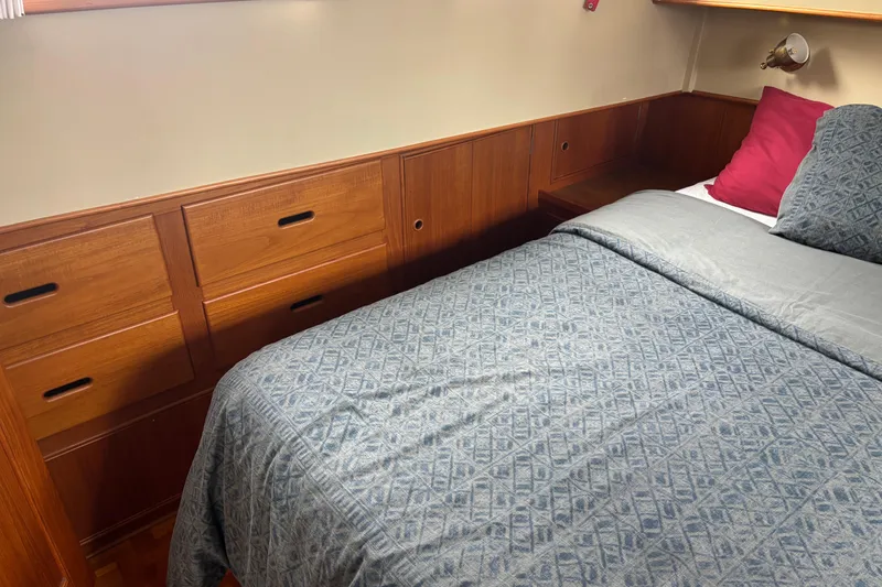Slide: The Image of Cozy bedroom in 1991 Grand Banks 36 Classic yacht with wooden cabinetry and patterned bedding. - 23
