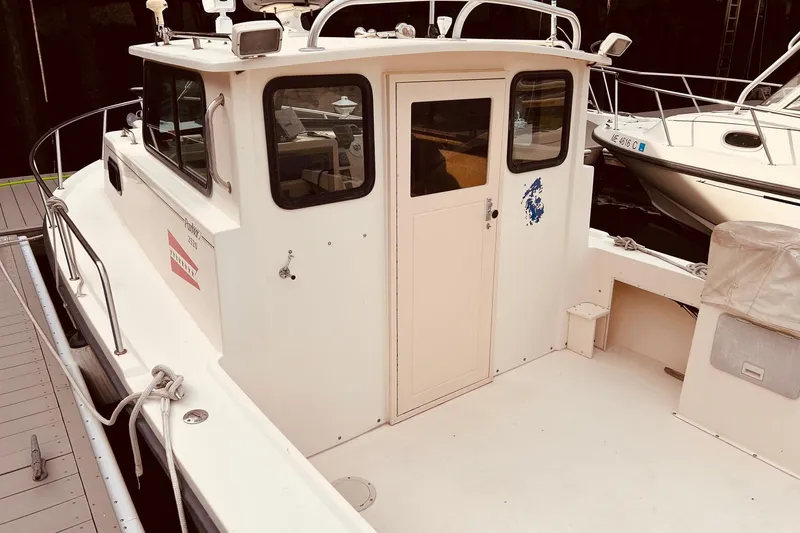 Slide: The Image of 2001 Parker 2520 Deep Vee Sport Cabin boat docked, featuring a spacious cabin and deck. - 10