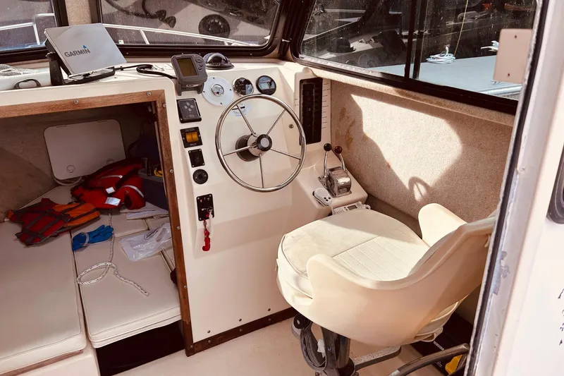 Slide: The Image of 2001 Parker 2520 Deep Vee Sport Cabin interior with steering wheel and navigation equipment. - 11