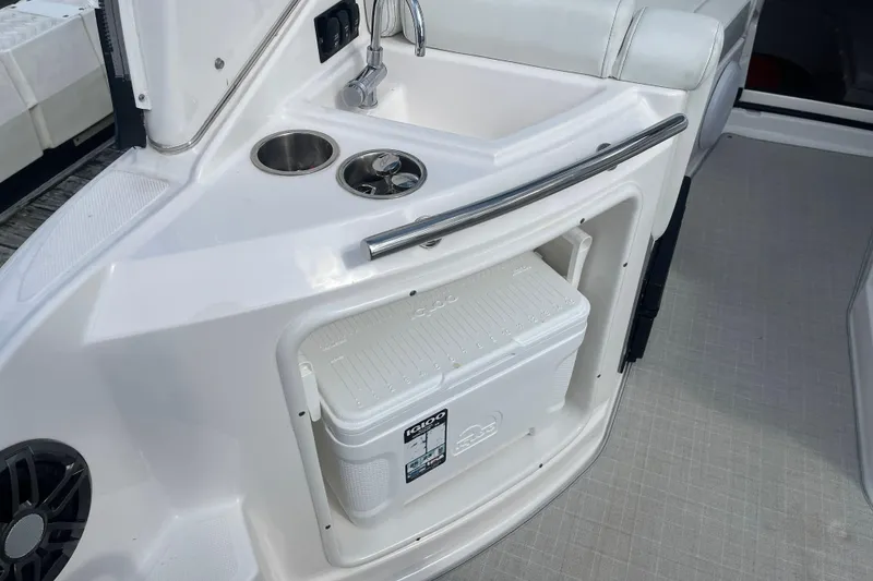 Slide: The Image of 2023 Regal 28 Express boat interior with sink, cup holders, and cooler storage. - 11