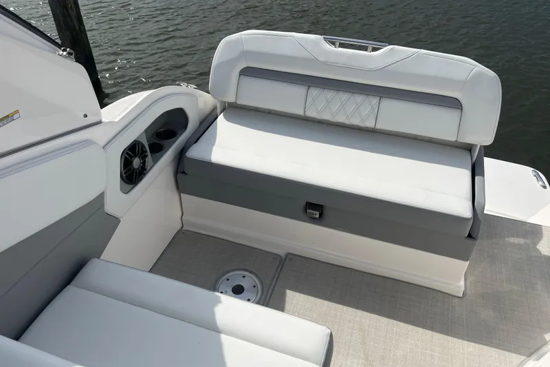 Slide: The Image of 2023 Regal 28 Express boat interior with cushioned seating and cup holders. - 12