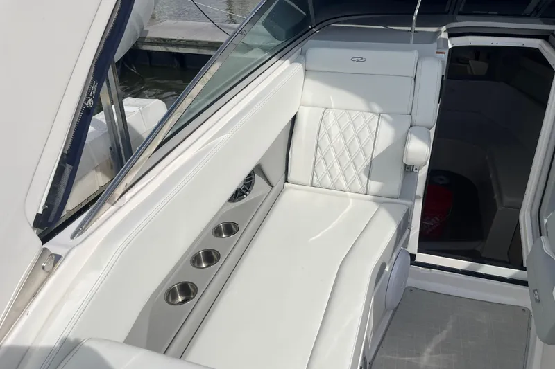 Slide: The Image of 2023 Regal 28 Express boat interior with white seating and cup holders. - 14