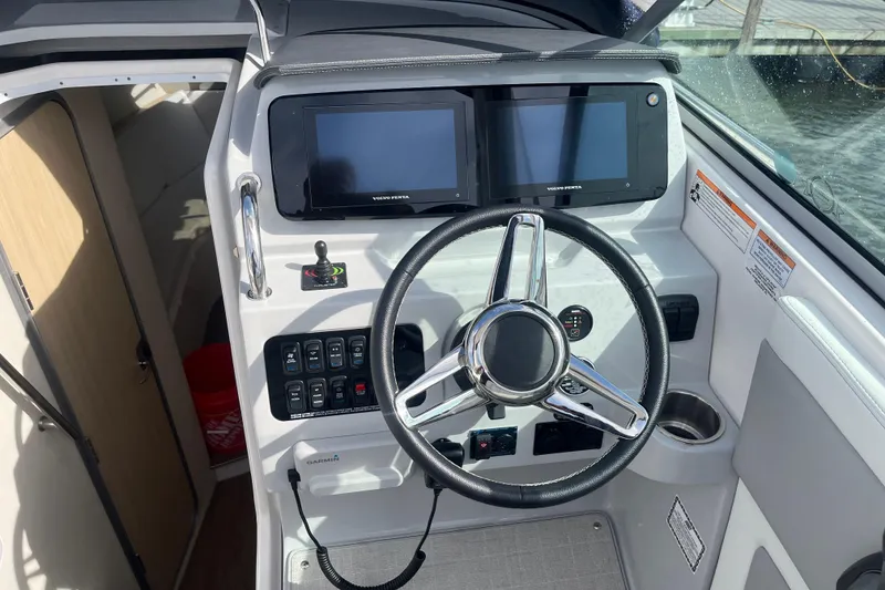Slide: The Image of 2023 Regal 28 Express boat helm with dual screens and modern controls. - 18