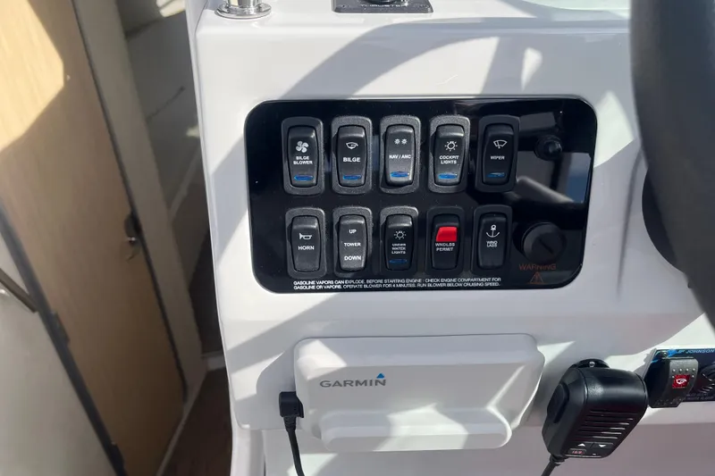 Slide: The Image of Control panel of 2023 Regal 28 Express boat with various switches and Garmin device. - 19