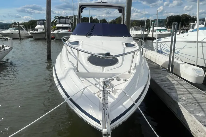 Slide: The Image of 2023 Regal 28 Express boat docked at marina under blue sky. - 2