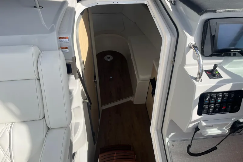 Slide: The Image of 2023 Regal 28 Express boat interior with helm controls and cabin entrance. - 23