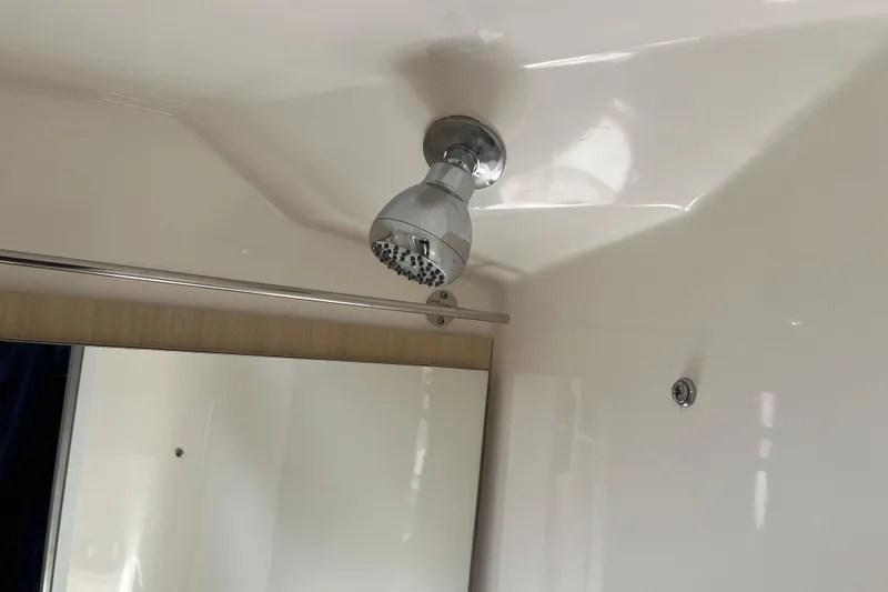 Slide: The Image of Shower area in 2023 Regal 28 Express boat, featuring a modern showerhead. - 30