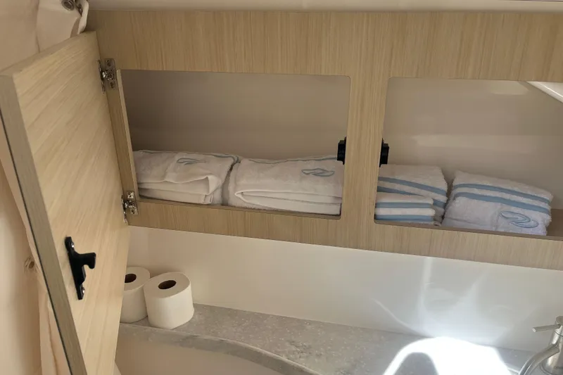 Slide: The Image of 2023 Regal 28 Express bathroom cabinet with towels and toilet paper. - 31