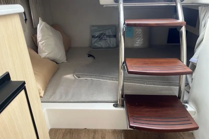 Slide: The Image of 2023 Regal 28 Express cabin interior with wooden steps and cozy bedding. - 32