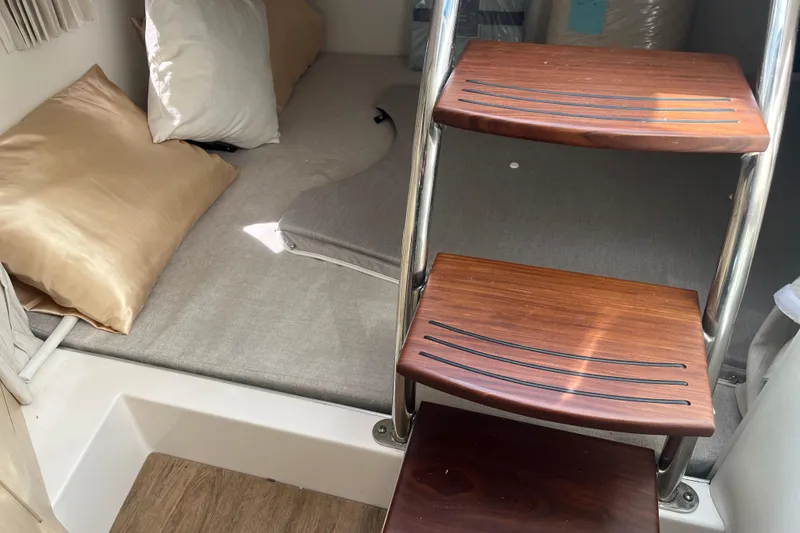 Slide: The Image of Interior cabin of 2023 Regal 28 Express boat with wooden steps and cozy bedding. - 33