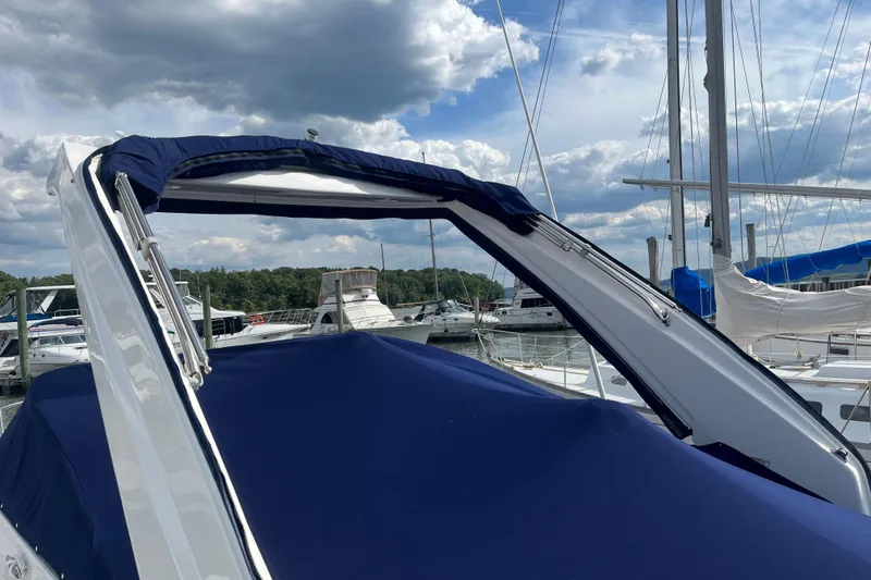 Slide: The Image of 2023 Regal 28 Express boat with blue cover docked at marina under cloudy sky. - 35