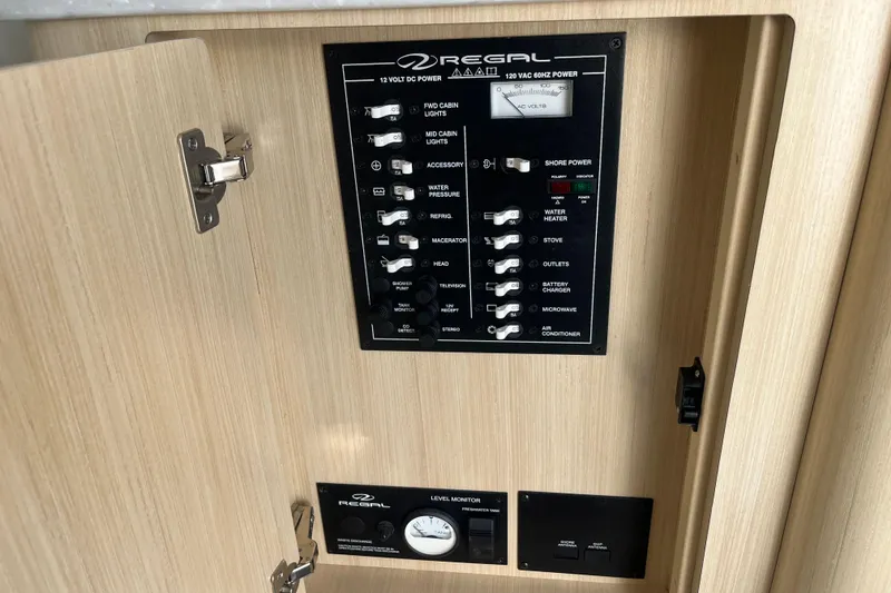 Slide: The Image of Control panel of 2023 Regal 28 Express boat, featuring switches and level monitor. - 39