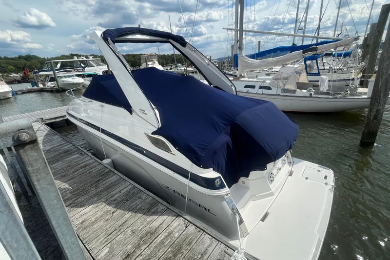 Slide: The Image of 2023 Regal 28 Express boat docked with blue cover, marina background. - 5