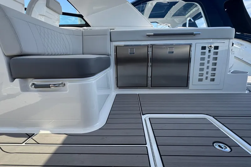 Slide: The Image of 2023 Sea Ray SLX 400 Outboard interior with sleek seating and stainless steel cabinetry. - 17