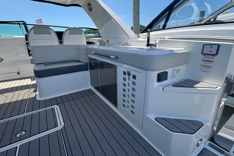 Slide: The Image of 2023 Sea Ray SLX 400 Outboard interior with seating and kitchenette on deck. - 18