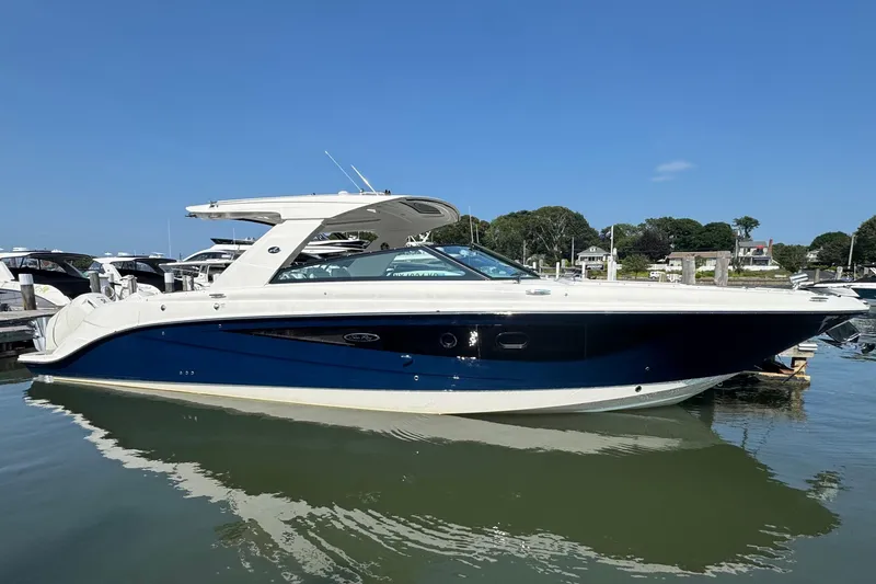 Slide: The Image of 2023 Sea Ray SLX 400 Outboard boat docked in a marina under clear blue sky. - 2