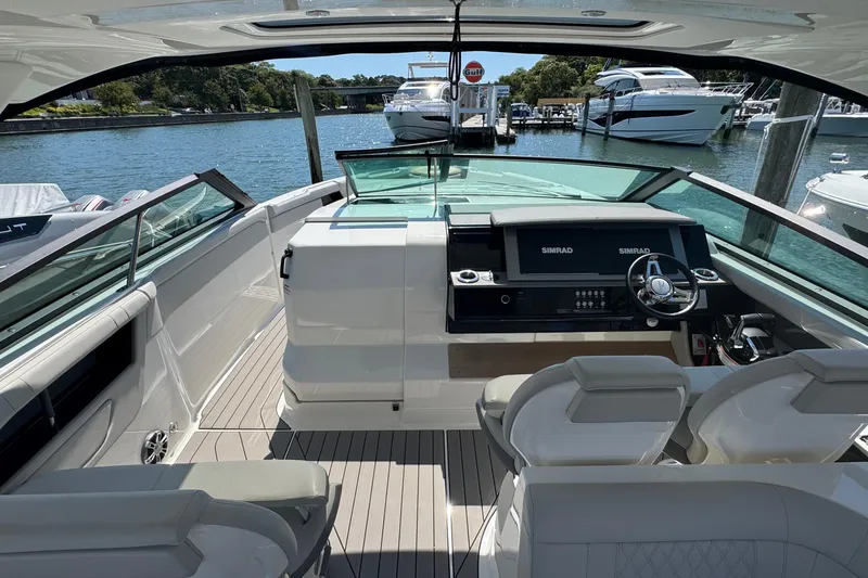 Slide: The Image of 2023 Sea Ray SLX 400 Outboard helm with dual Simrad displays, docked in a marina. - 21