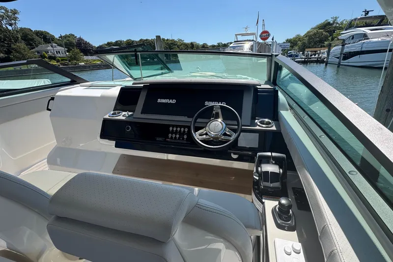 Slide: The Image of 2023 Sea Ray SLX 400 Outboard helm with Simrad display, docked in a marina. - 26