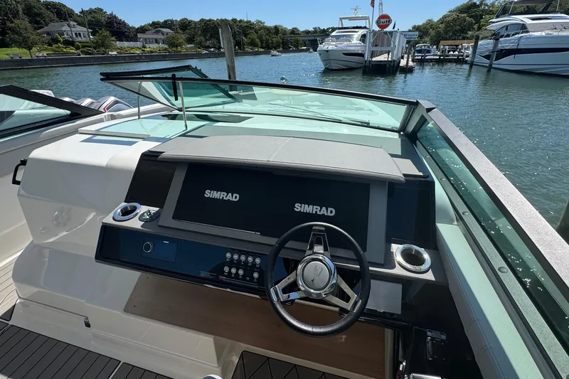 Slide: The Image of 2023 Sea Ray SLX 400 Outboard helm with dual Simrad displays, docked in a marina. - 27