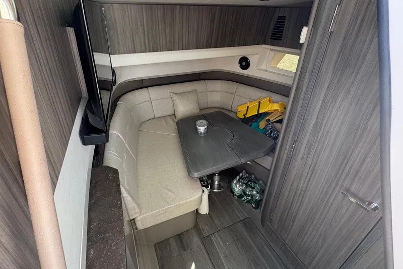 Slide: The Image of 2023 Sea Ray SLX 400 Outboard cabin interior with seating and table. - 30