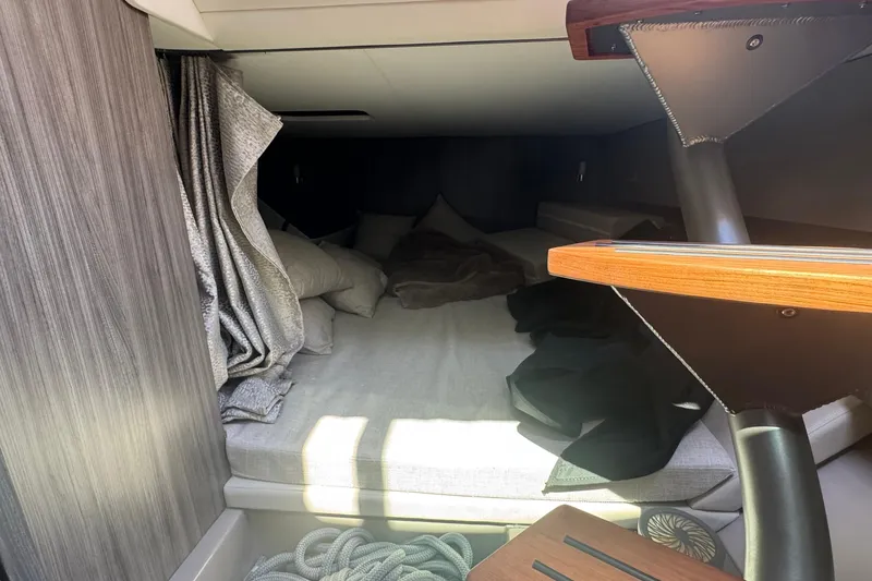 Slide: The Image of Cozy cabin interior of 2023 Sea Ray SLX 400 Outboard with bed and wooden stairs. - 32