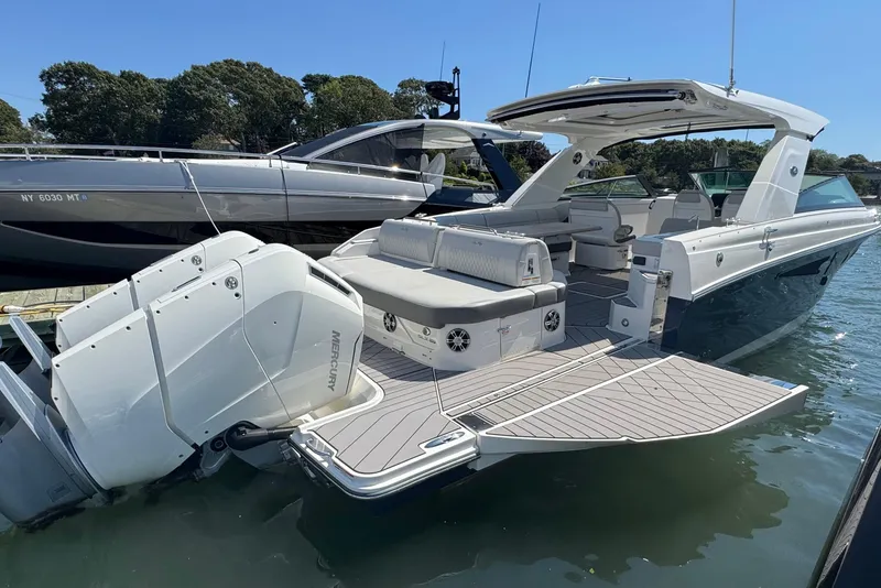 Slide: The Image of 2023 Sea Ray SLX 400 Outboard luxury boat docked, featuring spacious deck and powerful engines. - 5