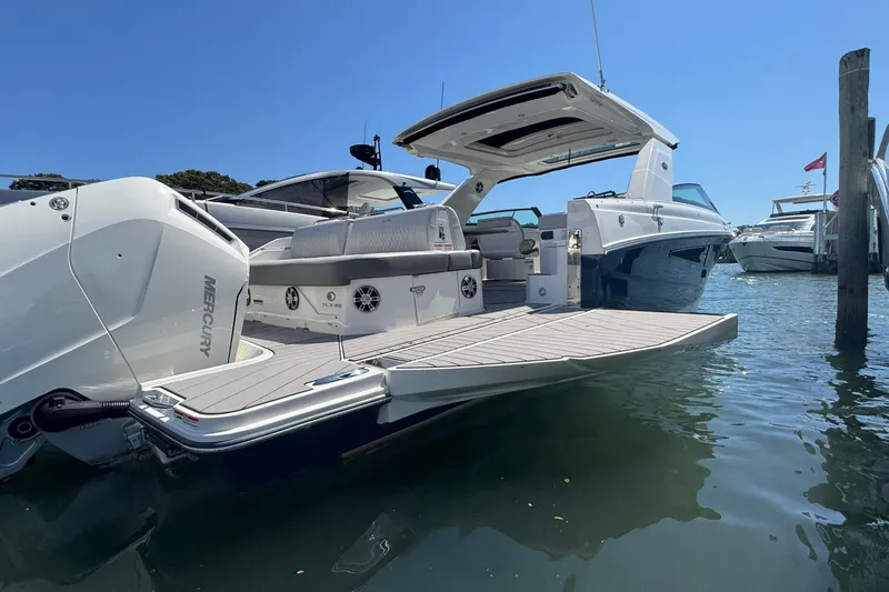 Slide: The Image of 2023 Sea Ray SLX 400 Outboard luxury boat docked, featuring spacious deck and modern design. - 6